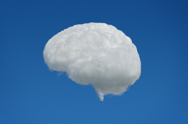 A white, cloudy, foggy brain shape against a blue sky background